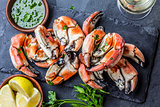 Crabs tentacles with wite wine, lemon, herbs sauce, slate background