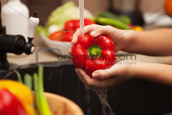Washing fresh vegetables for a healthy salad - the red bell pepp
