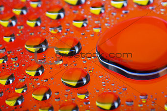 The Abstract orange red background with gradient color water drops on glass with reflection, big droplet, macro