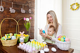 Easter concept. Happy mother and her cute child getting ready for Easter 