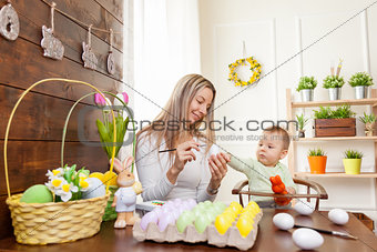 Easter concept. Happy mother and her cute child getting ready for Easter 