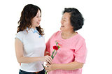Mother and daughter holding carnation flower and smiling