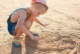 Cute little girl playing with sand on the beach