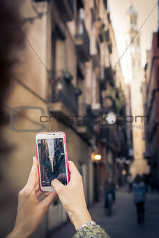 Hand hold a smartphone and make a photo with Santa Maria del Mar Cathedral in Barcelona, Spain