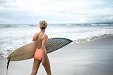 Girl with surfboard on beach