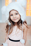 Portrait of adorable smiling child girl wearing fur hat