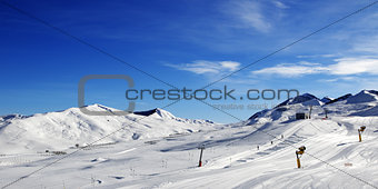 Panoramic view on ski slope with snowmaking at sun day