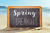text spring break in a chalkboard on the beach