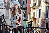 smiling trendy traveller woman in Venice, Italy in winter