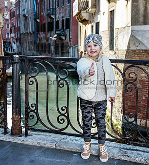 modern child in Venice, Italy in winter showing thumbs up