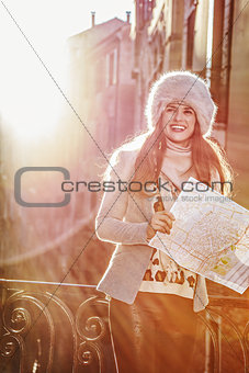 smiling tourist woman in Venice, Italy in winter with map