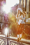 happy elegant tourist woman in Venice, Italy in winter with map