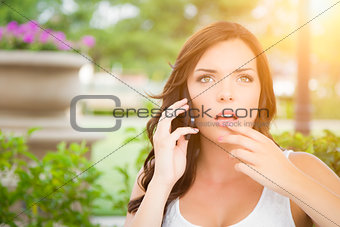 Shocked Young Adult Female Talking on Cell Phone Outdoors