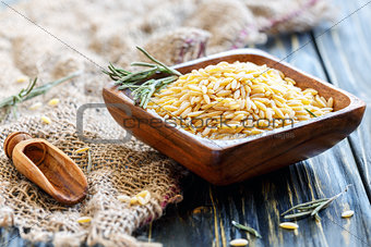 Italian pasta orzo in a wooden bowl.