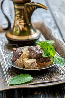 Plate with tahini halva with chocolate and jug.