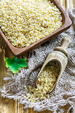 Wooden bowl and scoop with bulgur wheat.
