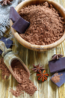 Wooden bowl with the cocoa powder and chocolate.