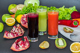 three glasses of different fresh juice. Beet, carrot and kiwi juices on grey background