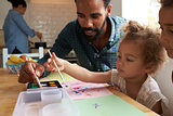 Children And Father Painting Picture On Kitchen Table