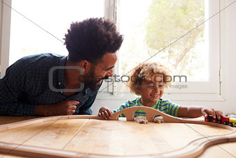 Father And Son Playing With Toy Train Set