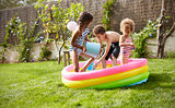 Children Having Fun In Garden Paddling Pool