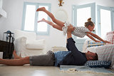 Father Lifting Daughter Into The Air Indoors
