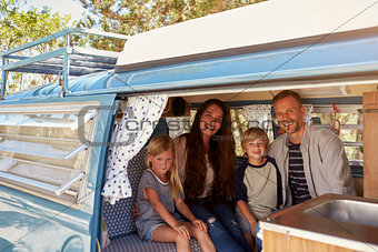 Family inside vintage camper van, seen through open door