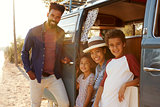 Young family make a stop on a road trip in their camper van