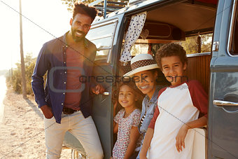 Young family make a stop on a road trip in their camper van