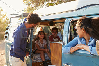 Family on a road trip making a stop in their camper van