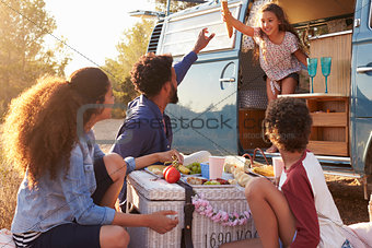 Daughter in camper van passing things out to her family,