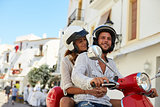 Young adult couple on a motor scooter in a street, Ibiza