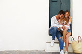 Young adult couple sitting together in doorway, Ibiza, Spain