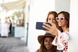 Three female friends taking a selfie in the street, Ibiza