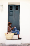 Young woman sitting on steps looking at phone, vertical