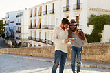 Young couple reading a guidebook in the street, Ibiza, Spain