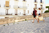 Couple on holiday walking with guidebook, holding hands