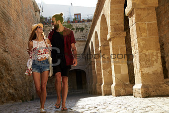 Couple sightseeing in Ibiza, looking at each other