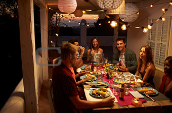 Friends talking at a dinner party on a patio, Ibiza, Spain