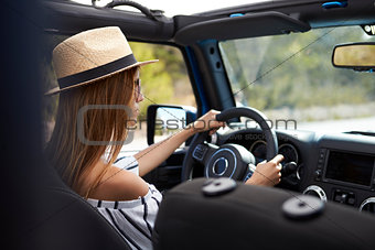 Young Woman Driving Open Top Car On Country Road