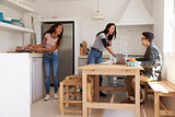 Teenagers making lunch and studying together in a kitchen