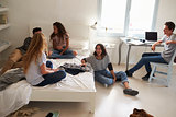 Five teenage friends hanging out together in bedroom