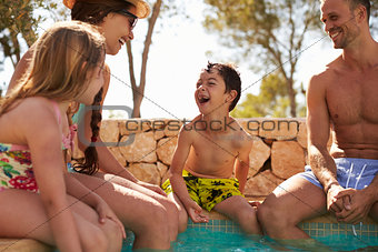 Family On Vacation Relaxing By Outdoor Pool