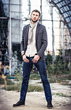 Fashion shot: portrait of handsome young man wearing jeans, shirt, jacket and scarf 