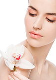 Beauty fashion model holding white orchid at spa