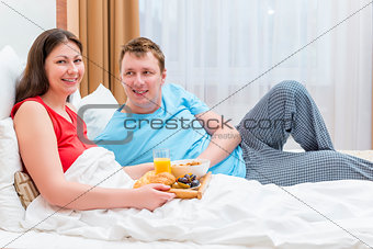 a married couple together breakfast in bed