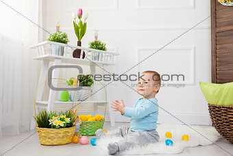 Easter egg hunt. Adorable child playing with Easter eggs at home