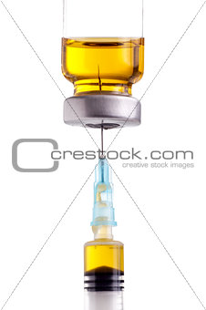 Syringe beeing filled with yellow liquid from medicin vial