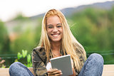 happy woman using a tablet outdoors