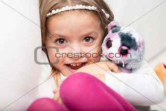 Cute laughing little girl with her fluffy toy
